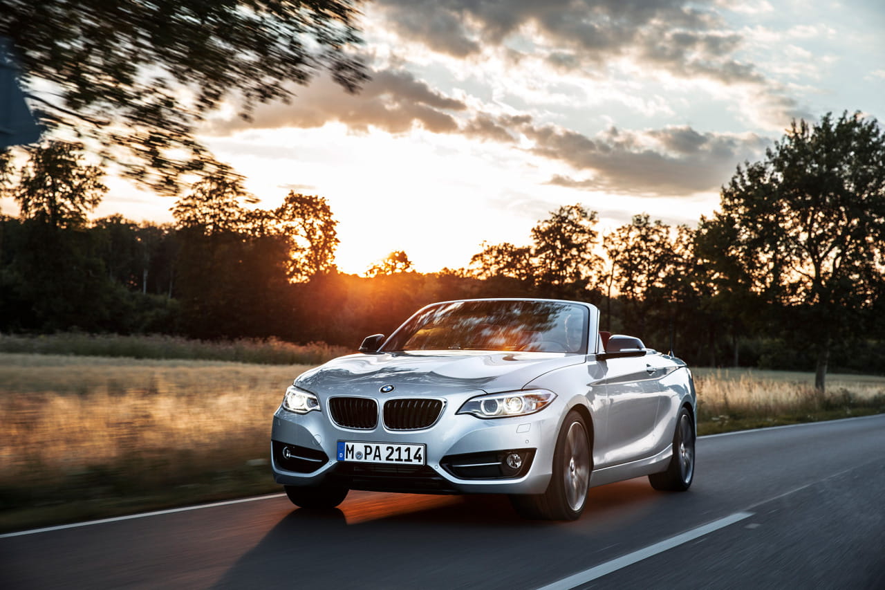 BMW Serie 2 Cabrio capturado con el techo abajo durante un atardecer.