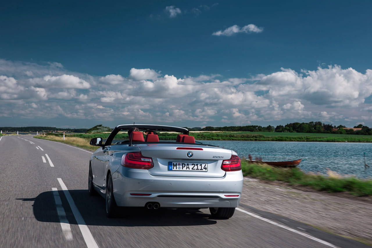 Vista trasera y lateral del BMW Serie 2 Cabrio en carretera