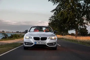 Vista frontal del BMW Serie 2 Cabrio en movimiento, evidenciando su diseño deportivo.