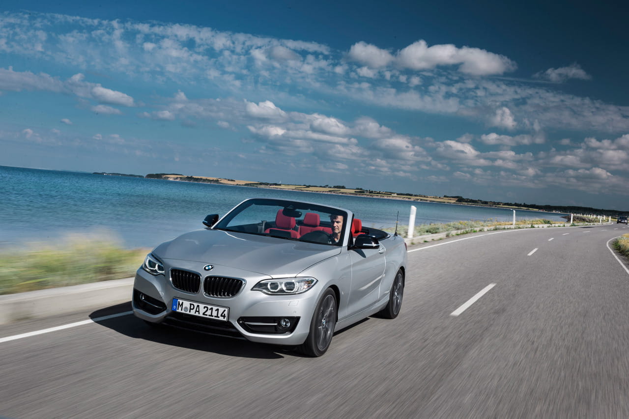 BMW Serie 2 Cabrio en movimiento con el techo bajado y vista lateral delantera.