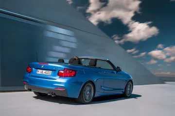 Vista trasera y lateral del BMW Serie 2 Cabrio, destacando su dinámica silueta.
