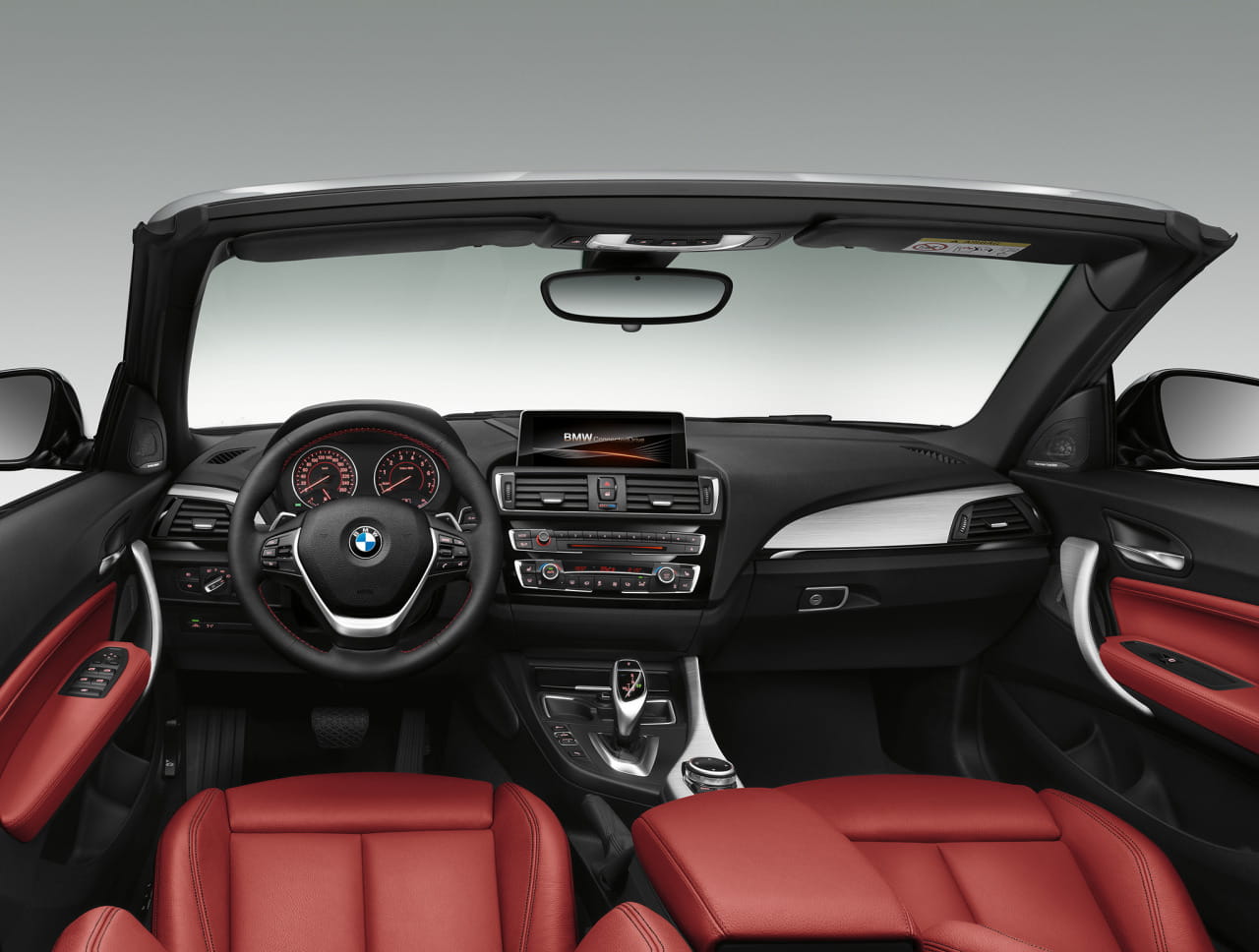 Vista del salpicadero y asientos delanteros en cuero rojo del BMW Serie 2 Cabrio.