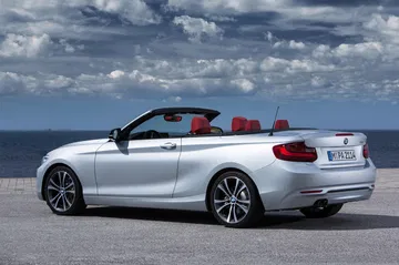 Vista lateral con la capota bajada del BMW Serie 2 Cabrio, mostrando líneas deportivas.