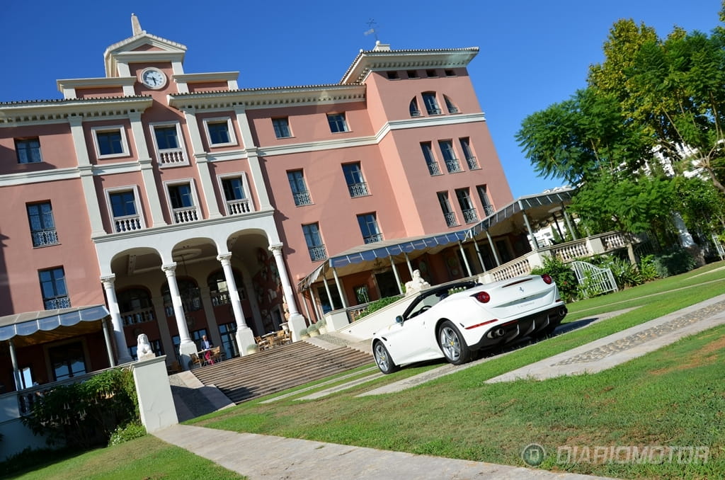 Ferrari California T aparcado frente a edificio elegante, vista lateral.