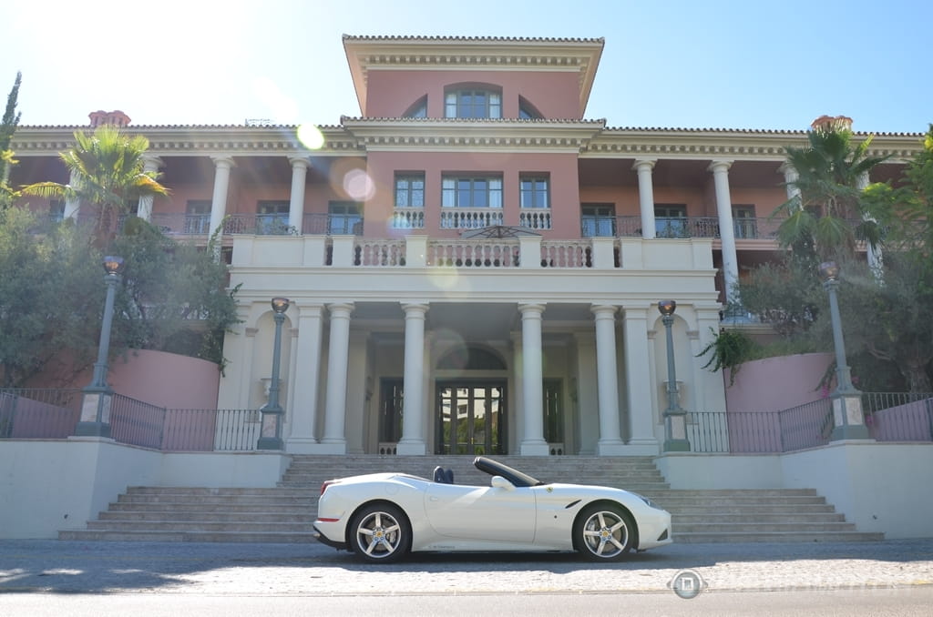 Ferrari California T apreciado en su perfil lateral frente a una mansión.