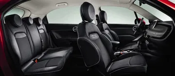 Vista lateral del habitáculo del Fiat 500X mostrando la disposición y acabado de los asientos.