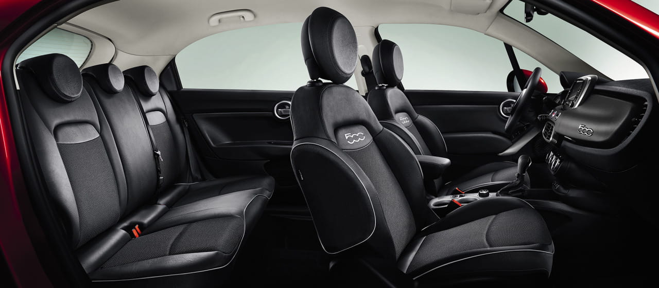 Vista lateral del habitáculo del Fiat 500X mostrando la disposición y acabado de los asientos.