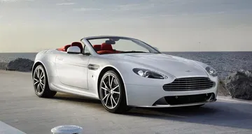 Aston Martin Vantage Volante captado en movimiento, vista delantera y lateral. Aston Martin Vantage Volante captado en movimiento, vista delantera y lateral.