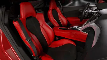 Vista de los asientos deportivos de cuero rojo del Honda NSX, con detalle de costuras.