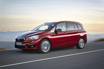 Vista lateral del BMW Serie 2 Gran Tourer en carretera al atardecer.