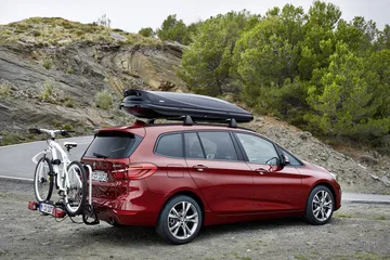 Vista lateral del BMW Serie 2 Gran Tourer con portaesquís y portabicicletas.