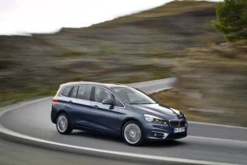 Vista dinámica del BMW Serie 2 Gran Tourer en carretera serpenteante.