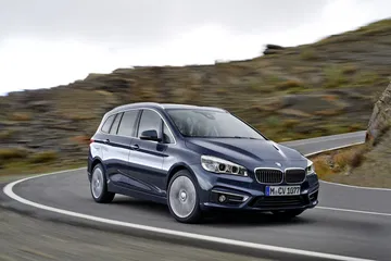 Vista lateral del BMW Serie 2 Gran Tourer en carretera, mostrando líneas dinámicas.