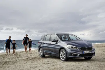 Vista lateral del BMW Serie 2 Gran Tourer en ambiente costero.