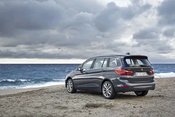 Vista lateral y trasera del BMW Serie 2 Gran Tourer con un fondo marítimo.