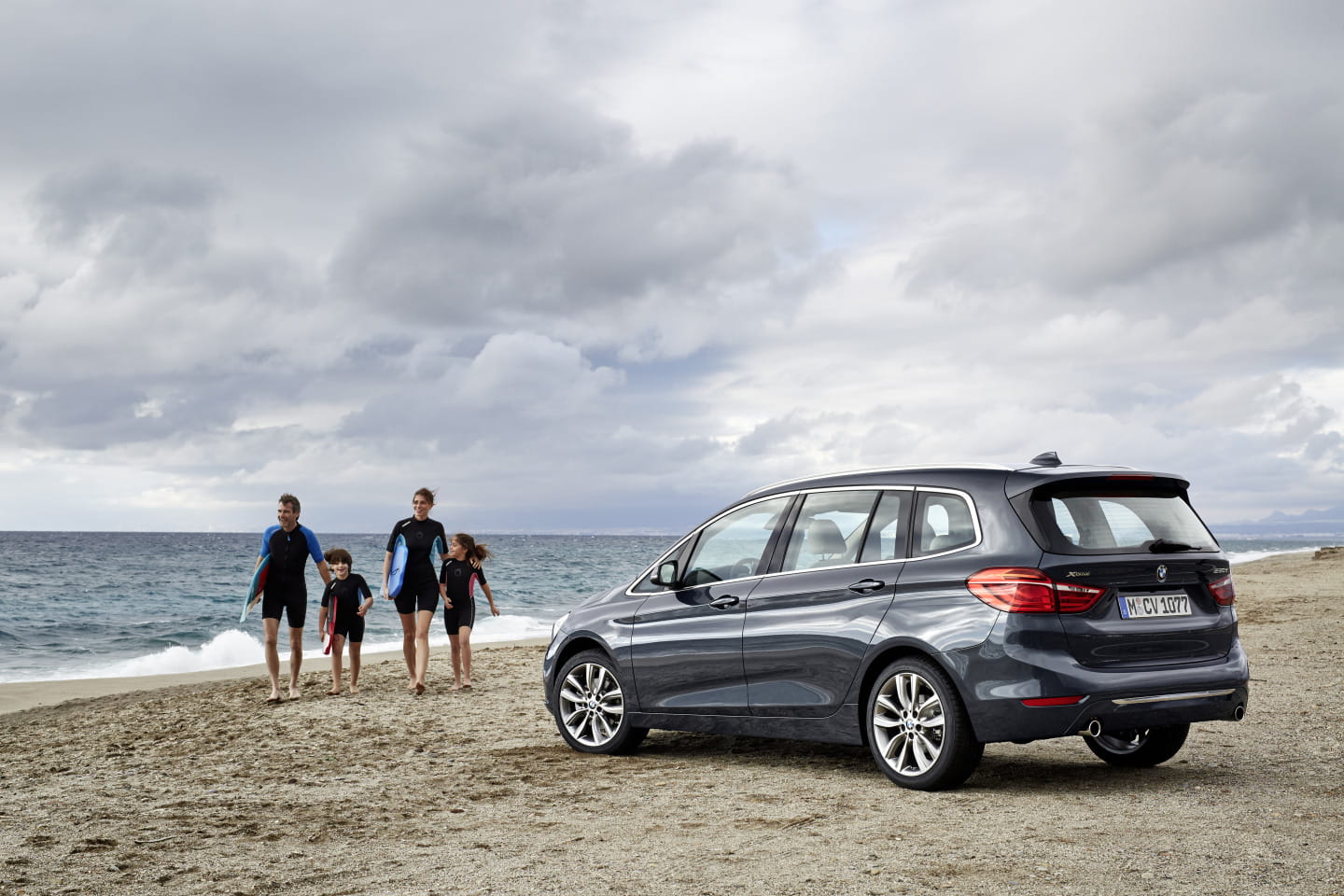 Vista lateral del BMW Serie 2 Gran Tourer frente a la playa, resaltando su diseño familiar.