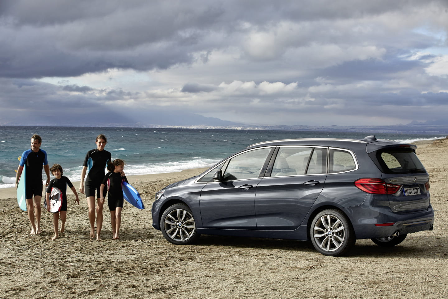 Vista lateral del BMW Serie 2 Gran Tourer en un entorno playero, destacando su línea y diseño.