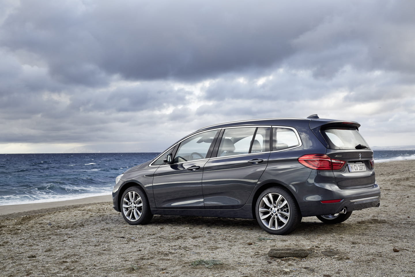 Vista lateral del BMW Serie 2 Gran Tourer en playa, diseño fluido y elegante.
