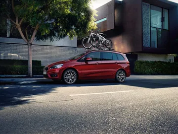 Vista lateral BMW Serie 2 Gran Tourer con bicicletas en el techo.