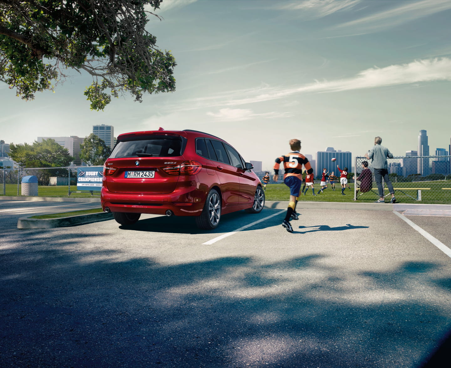 Vista trasera lateral del BMW Serie 2 Gran Tourer en color rojo, estacionado al aire libre.