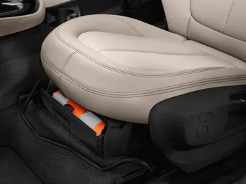 Asiento en cuero beige con ajustes manuales y diseño ergonómico.