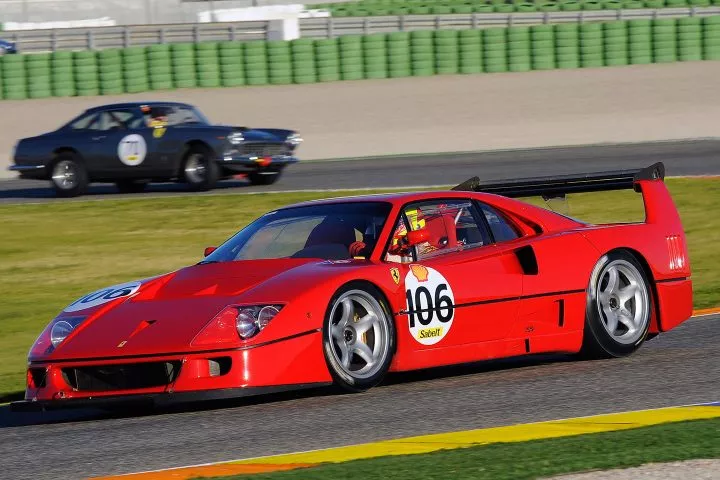 Vista lateral del Ferrari F40 en movimiento en un circuito, destacando su perfil aerodinámico.