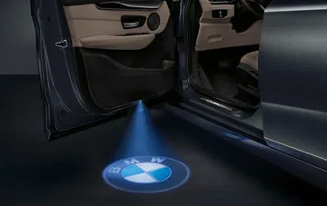 Proyección del emblema BMW al abrir la puerta, un detalle de cortesía elegante.