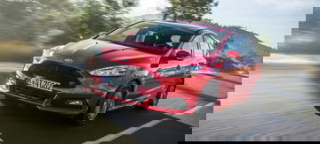 Vista dinámica del Ford Focus ST en rojo, destacando su diseño frontal y lateral