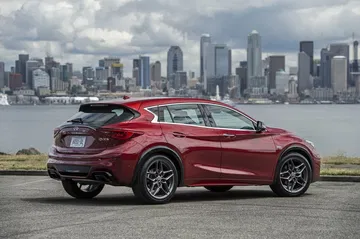 Vista trasera lateral del Infiniti QX30 con fondo urbano.