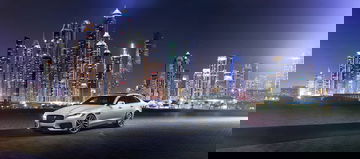 Vista frontal y lateral del Jaguar XF con un impresionante fondo urbano nocturno