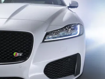 Vista enfocada en la parrilla y faros delanteros del Jaguar XF, mostrando un diseño agresivo y elegante.
