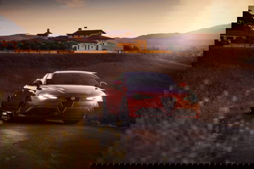 Alfa Romeo Giulia capturado en pleno manejo al amanecer, resaltando su diseño frontal.