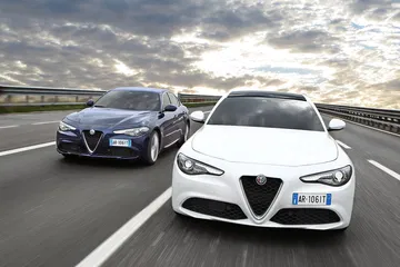 Dos Alfa Romeo Giulia avanzando agresivamente en la carretera