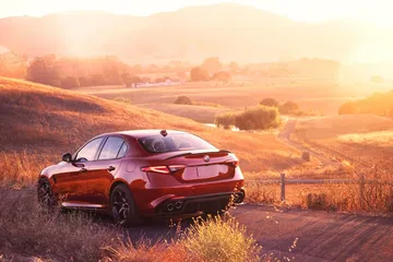 Alfa Romeo Giulia mostrando su diseño trasero y lateral al atardecer.