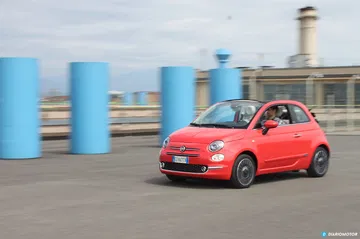 Vista dinámica del Fiat 500 en movimiento, destacando su diseño lateral compacto.