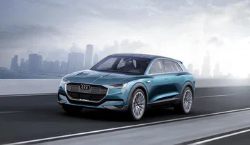 Vista dinámica del Audi e-tron quattro mostrando su elegante perfil delantero.