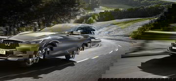 Vista dinámica del Infiniti Q30 en carretera, destacando su diseño frontal y lateral.