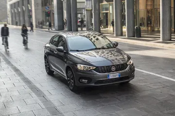 Vista dinámica del Fiat Tipo en ambiente urbano, destacando su frontal y línea lateral.