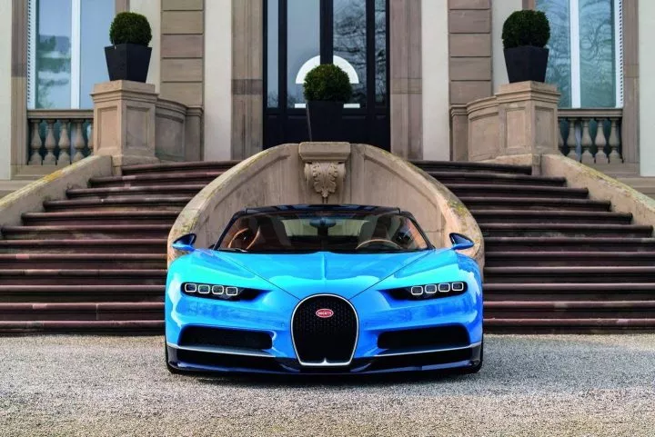 Vista frontal del Bugatti Chiron con una elegante residencia de fondo