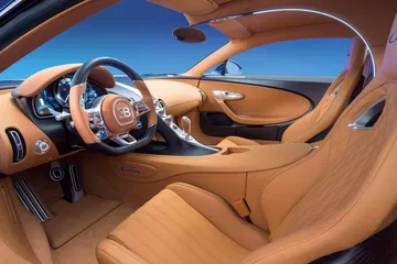 Lujoso interior del Chiron, tapicería de cuero cognac y volante detallado.