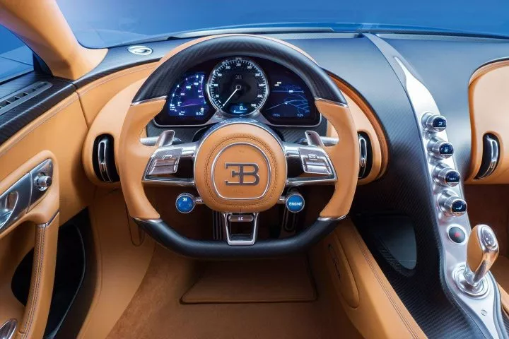 Vista cercana del volante y tablero del Bugatti Chiron, resaltando su lujoso acabado.
