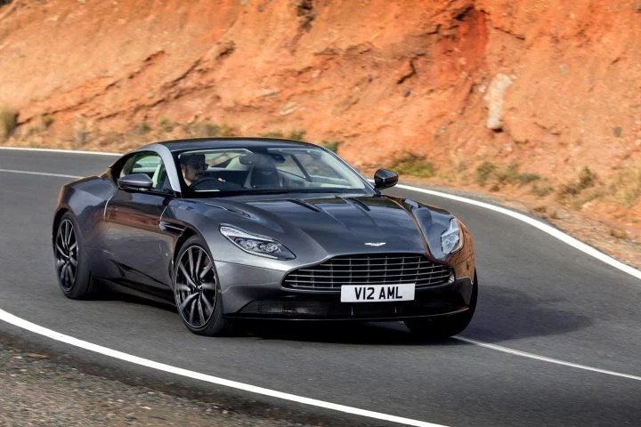 El Aston Martin DB11 en movimiento, mostrando su dinámica silueta y poderosa presencia.