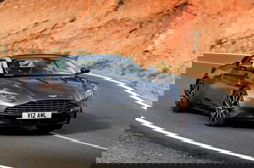 El Aston Martin DB11 en movimiento, mostrando su dinámica silueta y poderosa presencia.