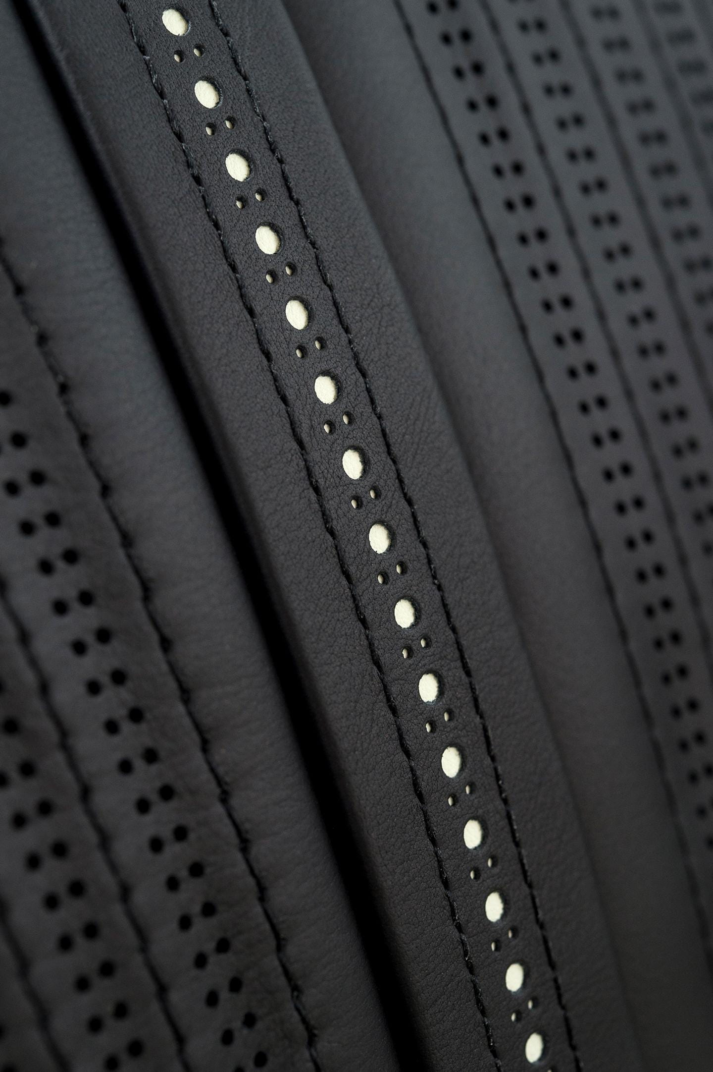 Vista cercana de la costura y perforación del cuero de los asientos del DB11.