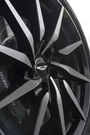 Primer plano de un rin del Aston Martin DB11, mostrando la marca y diseño.