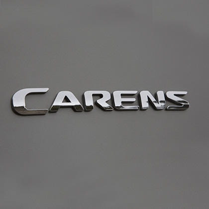 Vista cercana del emblema distintivo del Kia Carens.