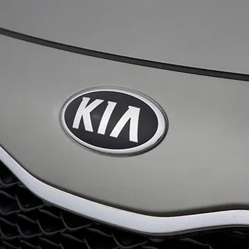 Vista cercana del icónico logo de Kia en el Carens.