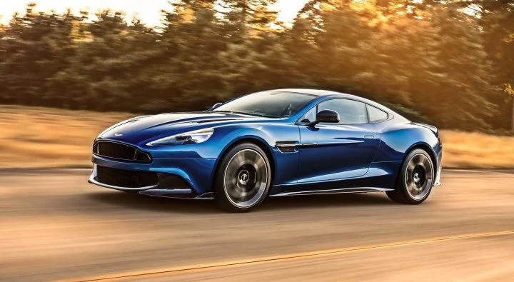 Vista lateral de un Aston Martin Vanquish S en movimiento, color azul.