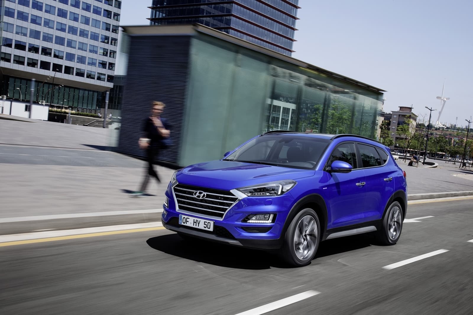 Vista dinámica del Hyundai Tucson en entorno urbano, color azul.