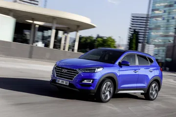 Vista dinámica del Hyundai Tucson mostrando su diseño lateral y frontal.